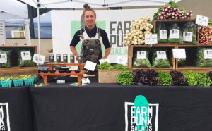 Quinn at the Farm Punk Salads booth at a farmers market